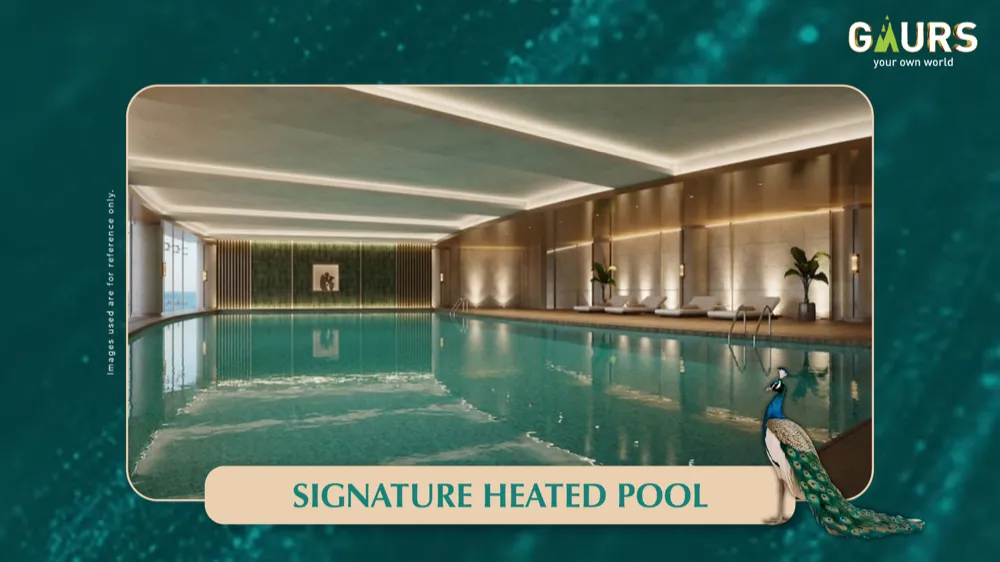 Signature heated indoor pool at Gaur Alaris clubhouse with loungers along one wall